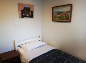 sypialnia z łóżkiem i 2 zdjęciami na ścianie w obiekcie Nice house on Wesley Auckland w Auckland