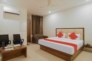 een slaapkamer met een bed, een bureau en een stoel bij Hotel Golfview in Panchkula