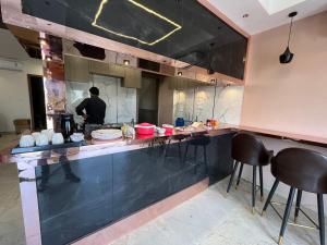 een keuken met een aanrecht waar een man eten klaarmaakt bij Kasa Comfort Inn in Indore
