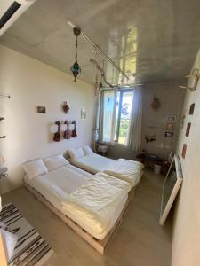 a bedroom with two beds and a window at Sesoko Blue in Sesoko