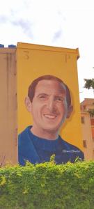 Un dipinto di un uomo sul lato di un edificio di Ciccio Rooms and breakfast a Palermo