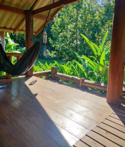 Pang Mapha的住宿－Pencave Homestay，木甲板上的吊床,种有树木