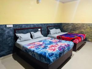 two beds sitting next to each other in a room at Maharaja Cottage in Munnar