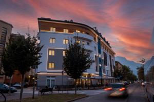 a building on a city street with a sunset at Hotel Everest in Trento