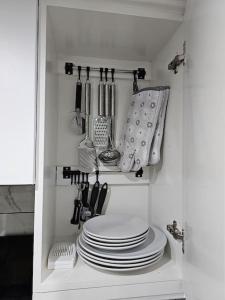 a shelf with plates and utensils in a kitchen at Cheerful Home near Preston train station & Uclan in Preston