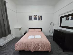Cheerful Home near Preston train station & Uclan في بريستون: غرفة نوم عليها سرير وفوط بيضاء