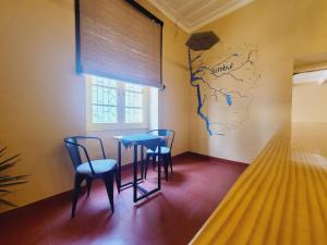 a table and chairs in a room with a map on the wall at Jambul House in Panaji
