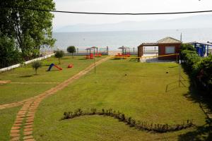 un parc avec une aire de jeux avec l'océan en arrière-plan dans l'établissement Biscoutsis Apartments & Studios, à Kavos