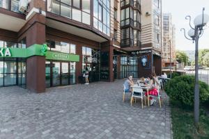 a group of people sitting at tables outside of a building at Atlant luxury Big Family Perlina Apart on Golovna з двома санвузлами поряд з ТЦ Депот in Chernivtsi