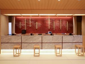 a lobby with a reception counter and stools at Beppu Hatto Onyado Nono Beppu in Beppu