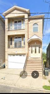 a large brick house with a white garage at Business & Family Friendly Balcony Jacuzzi Free Park in Jersey City