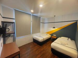 a hotel room with two beds and a desk and a table at Smile Hotel Putrajaya in Putrajaya