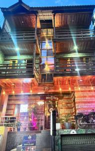 un restaurante con un edificio de ladrillo con luces encendidas en The yerpa Hotel, en Kasol