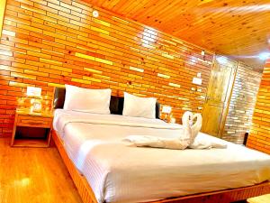 a bedroom with two beds with a person laying on it at The yerpa Hotel in Kasol