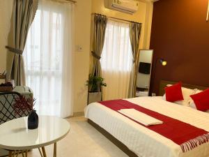 1 dormitorio con cama, mesa y ventana en Acorn Saigon Hotel - Bui Vien en Ho Chi Minh