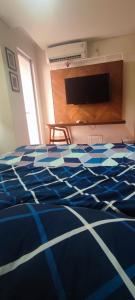 - une chambre avec un lit bleu et blanc et une télévision dans l'établissement Bicon Homey, à South Tangerang