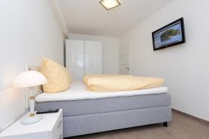 ベンサージールにあるResidenz Hafenidyllの小さなベッドルーム(ベッド1台、ランプ付)