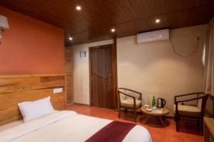 ナガルコットにあるEverest Manla Resortのベッドルーム1室(ベッド1台、テーブル、椅子付)
