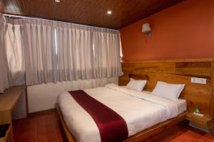 a bedroom with a large bed with white sheets at Everest Manla Resort in Nagarkot