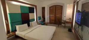 sypialnia z dużym białym łóżkiem i biurkiem w obiekcie The Promenade w mieście Puducherry