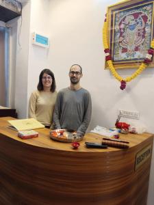 a man and a woman standing at a counter at Hotel Balaji Residency in Udaipur