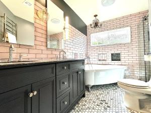 a bathroom with a tub and a toilet and a sink at 2 BR 2 BA - Eco House and Garden Vacation Retreat and Remote Workspace for Families, Couples and Solo Travelers in Coveted Culver in Culver City +24 photos
