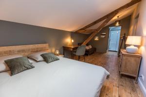 a bedroom with a large white bed and a desk at La maison d'à côté in Mont-de-Marsan