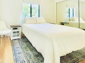 a large white bed in a room with a mirror at 2 BR 2 BA - Eco House and Garden Vacation Retreat and Remote Workspace for Families, Couples and Solo Travelers in Coveted Culver in Culver City