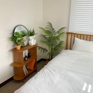 a bedroom with a bed and plants on a night stand at Maison de Haenggung in Suwon