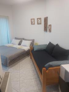 salon z łóżkiem i kanapą w obiekcie Apartmani Sladojević w mieście Mrkonjić Grad