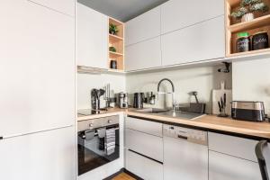 uma cozinha com armários brancos e um lavatório em Luxury 2BR Penthouse with City Skyline Terrace, near Kolonaki em Atenas