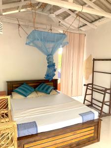 a bedroom with a bed with a blue umbrella at Salty Fish Mirissa in Mirissa
