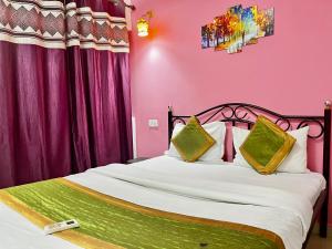 - une chambre avec un grand lit aux murs roses dans l'établissement Dipty Welcome Stay, à Vagator
