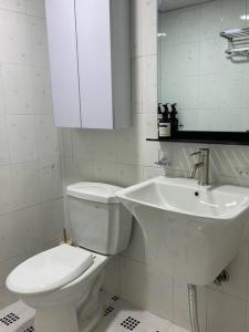 Baño blanco con aseo y lavamanos en Maison de Haenggung, en Suwon