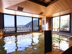 a large indoor pool with a view of a mountain at Beppu Hatto Onyado Nono Beppu in Beppu