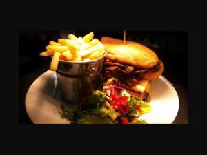 a sandwich and french fries on a plate with a salad at The Old Bell in Shrewsbury