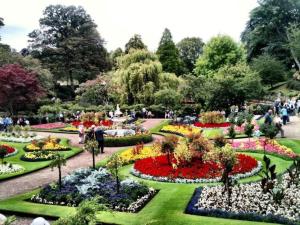 un jardín con flores y gente caminando alrededor de él en The Old Bell, en Shrewsbury