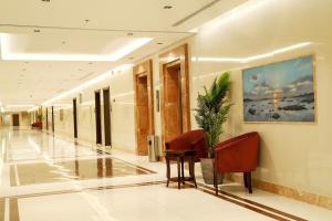 a hallway with a table and chairs in a building at Ofoq Al Raha Hotel Apartment in Taif