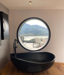 a round window in a bathroom with a black tub at Les Restanques du lac in La Chapelle