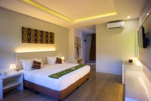Grand Harvest Resort & Villas في بانيووانجى: غرفة نوم مع سرير أبيض كبير في غرفة