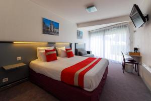 a hotel room with a large bed and a desk at Logis Hôtel Le Rochelois in La Rochelle