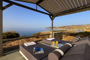 um pátio com uma mesa e vista para o oceano em Martineli Residence - A Beachfront Estate em Drios