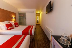 a hotel room with two beds and a flat screen tv at Logis Hôtel Le Rochelois in La Rochelle