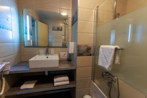 a bathroom with a sink and a mirror at Logis Hôtel Le Rochelois in La Rochelle