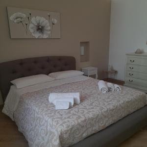 1 dormitorio con 1 cama con toallas y vestidor en Simarty Home, en Marsala