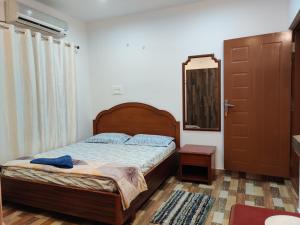 1 dormitorio con cama, espejo y puerta en SkyHouse Homestay, en Mysore
