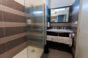 a bathroom with a sink and a mirror at Logis Hôtel Le Rochelois in La Rochelle