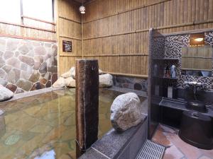 une salle de bain avec une baignoire et un lavabo dans une pièce dans l'établissement Beppu Hatto Onyado Nono Beppu, à Beppu