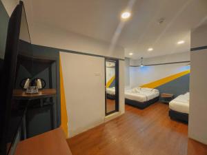 a room with two beds and a mirror at Smile Hotel Putrajaya in Putrajaya