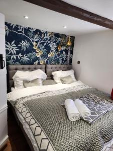 a bedroom with a large bed with towels on it at Rose & Star Cottage in Frome